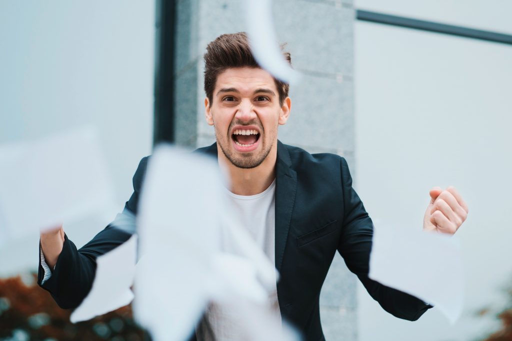 furious-male-office-worker-throwing-crumpled-paper